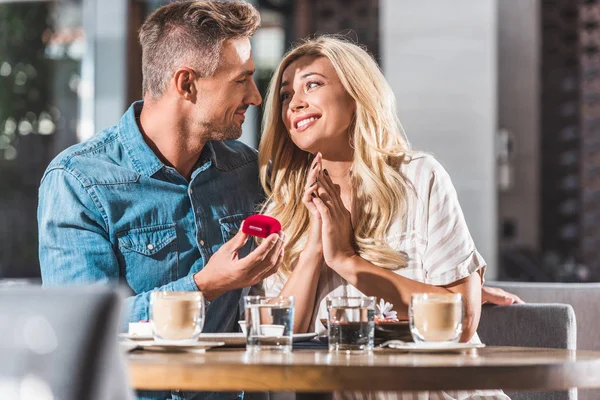 Bonito Namorado Propondo Feliz Namorada Segurando Vermelho Anel Caixa Café — Fotografia de Stock