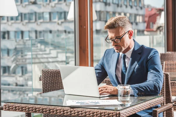 Homem Negócios Focado Óculos Usando Laptop Mesa Com Vidro Água — Fotografia de Stock