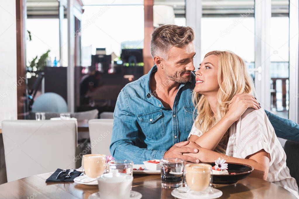 affectionate couple going to kiss during date in cafe