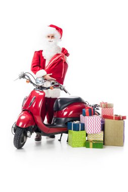 Noel Baba Noel ile çuval ayakta scooter ve beyaz arka plan üzerinde izole hediye kutuları yığını 