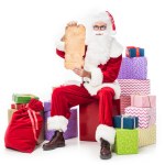 Santa claus montrant vieux parchemin vide et assis sur une pile de boîtes-cadeaux isolées sur fond blanc