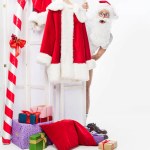Schockierter Weihnachtsmann ohne Kostüm schaut von Klappbildschirm isoliert auf weißem Hintergrund