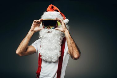 Noel Baba adjsuting kar maskesi gri arka plan üzerinde izole 