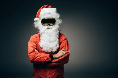 Noel Baba kar maskesi ve çapraz kolları üzerinde gri arka plan izole olan ayakta rüzgarlık 