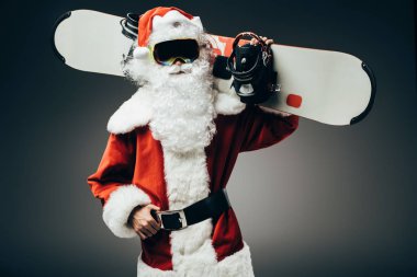 ciddi Noel Baba snowboard gri arka plan üzerinde izole omuz üzerinden ile kar maskesi ayakta 