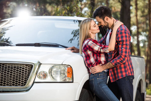 smiling young couple looking at each other near pick up car outdoors 