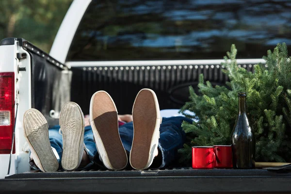 クリスマス ツリーとシャンパン ボトル屋外で車のトランクに敷設する若いカップルの選択と集中 — ストック写真