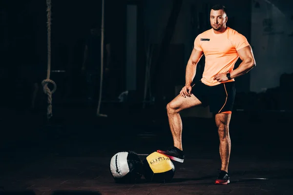 Handsome Athletic Bodybuilder Standing Dark Gym Medicine Balls Floor Looking — Stock Photo, Image