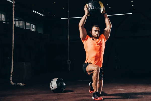 Handsome Athletic Bodybuilder Performing Lunge Medicine Ball Overhead Dark Gym — Stock Photo, Image