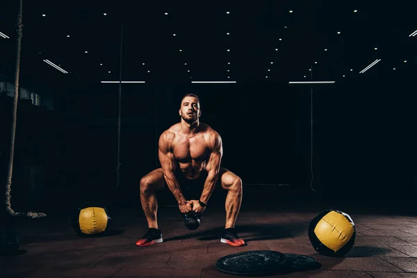Schöner Athletischer Bodybuilder Macht Kniebeugen Mit Kettlebell Dunkler Turnhalle — Stockfoto