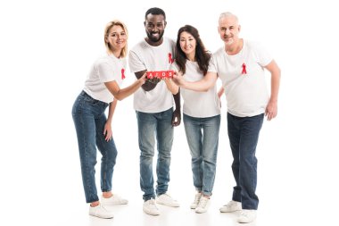AIDS bilinçlendirme kırmızı üzerine beyaz izole blok yazı AIDS ile tutarak şeritler boş beyaz t-shirt çok ırklı insanlarda gülümseyen