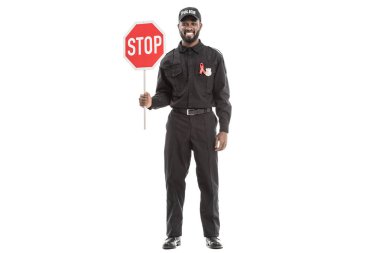 AIDS bilinçlendirme kırmızı şerit ve üzerinde beyaz izole dur yol işareti ile mutlu Afro-Amerikan polis memuru