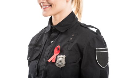 cropped shot of smiling female police officer with aids awareness red ribbon isolated on white clipart