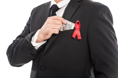 işadamı AIDS bilinçlendirme kırmızı kurdele holding prezervatif üzerinde beyaz izole ile takım elbiseli kırpılmış atış
