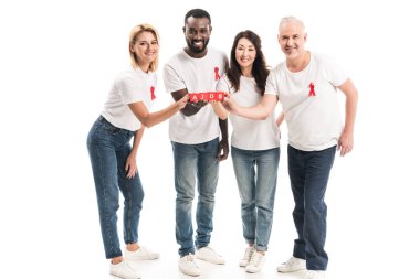 group of multiethnic people in blank white t-shirts with aids awareness red ribbons holding blocks with AIDS lettering isolated on white clipart