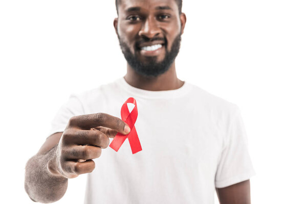 close-up shot of african american man in blank white t-shirt with aids awareness red ribbon looking at camera isolated on white