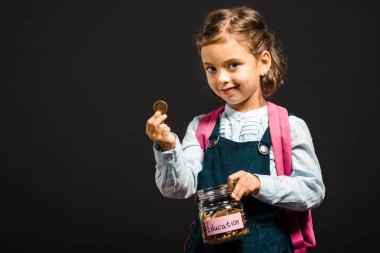 schoolgirl with backpack holding glass jar with savings for education isolated on black clipart
