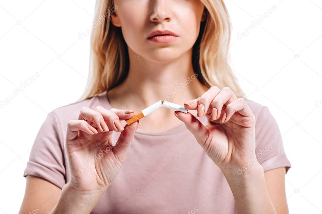 cropped image of blonde woman breaking unhealthy cigarette isolated on white