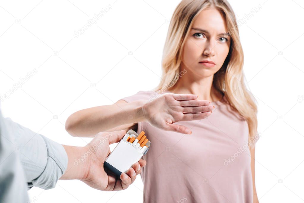 attractive woman rejecting pack of cigarettes from man isolated on white