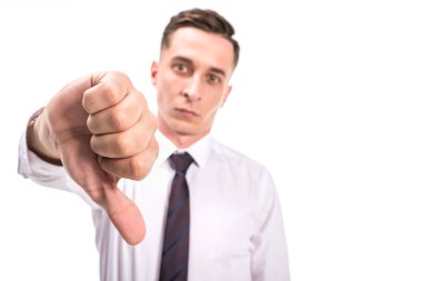 selective focus of man showing thumb down and looking at camera isolated on white clipart