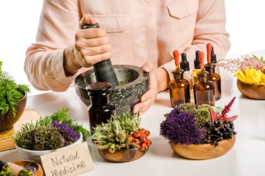 cropped image of woman preparing natural medicines with mortar and pestle isolated on white clipart