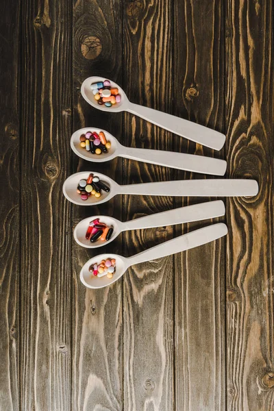 Top View Five Spoons Pills Wooden Tabletop — Free Stock Photo