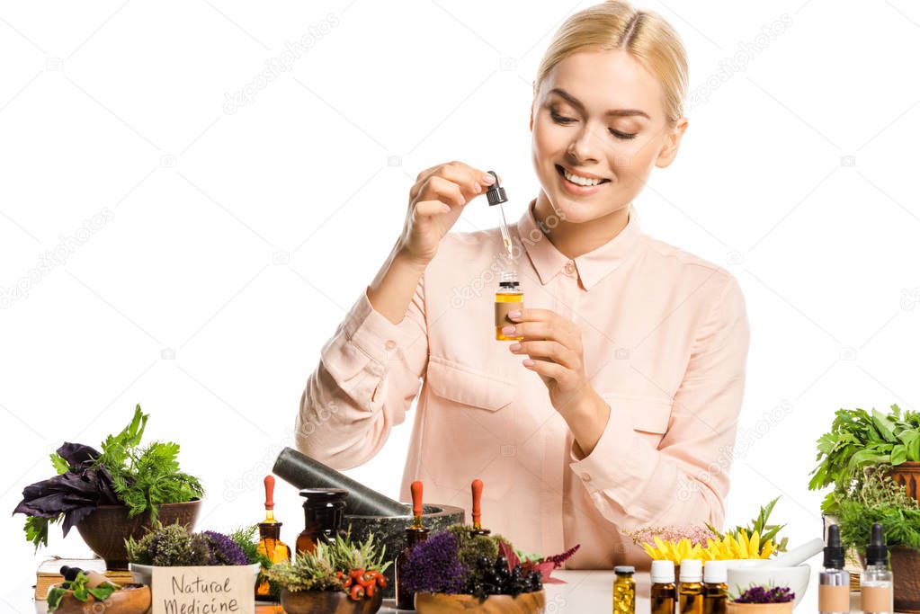 smiling woman making essential oil isolated on white