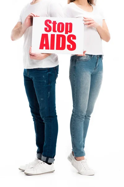 白で隔離 Stop エイズ テキストとカードを保持しているカジュアルな服で異性カップルのトリミングされた画像 — ストック写真