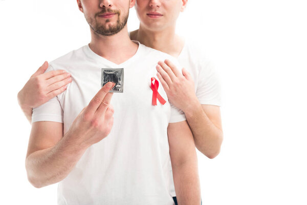 cropped image of boyfriends hugging and holding condom isolated on white, world aids day concept