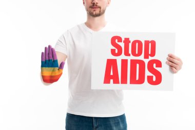 bir adam eliyle dur işareti gösterilen kırpılmış görüntü üzerinde beyaz izole stop AIDS metinle gökkuşağı ve holding kartı boyalı