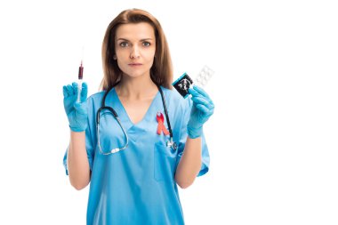 izole üzerinde beyaz, Dünya AIDS Günü kavramı kırmızı kan şırınga ve prezervatif ile tutarak kurdele ile çekici Doktor hap