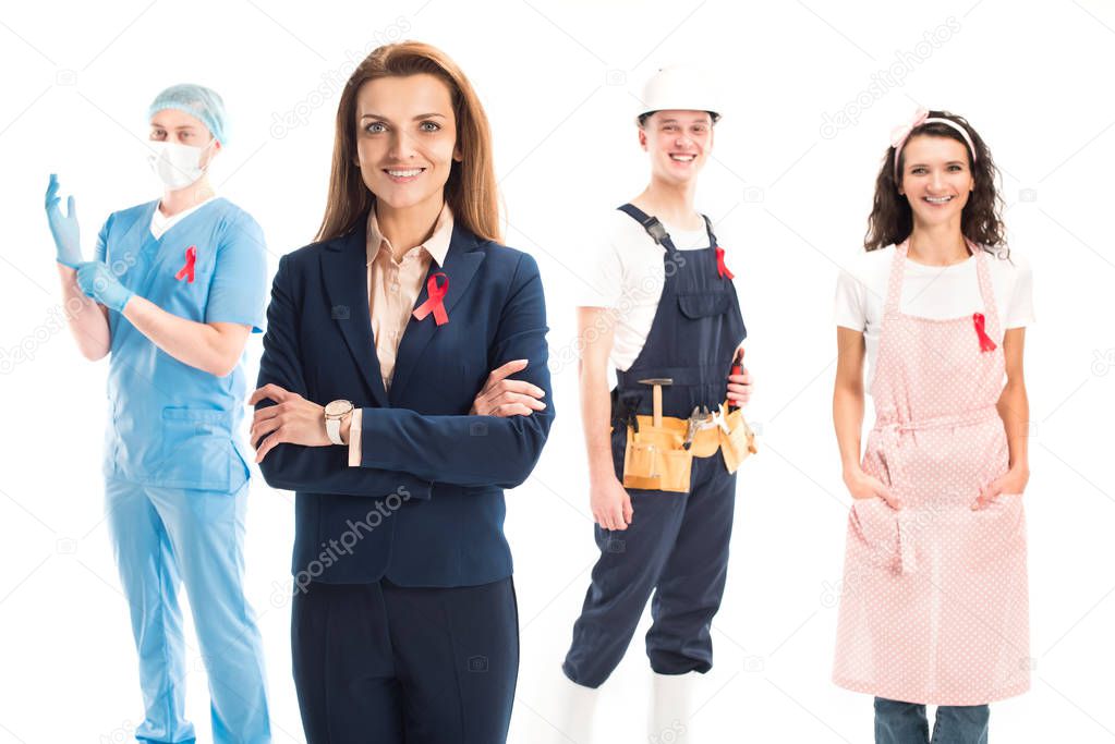 smiling businesswoman, doctor, worker and housewife standing with red ribbons isolated on white, world aids day concept