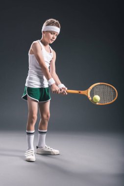 spor tenis raketi ve koyu arka plan üzerinde topu taşımak çocuk