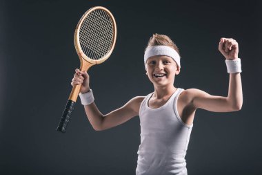 spor tenis raketi koyu arka plan üzerinde ile mutlu çocuk portresi