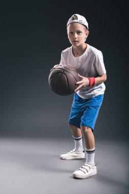 şık çocuk gri arka plan üzerinde basketbol oynarken