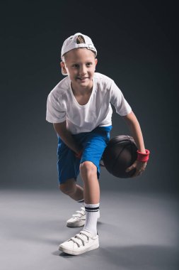 şık çocuk gri arka plan üzerinde basketbol oynarken