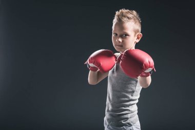 siyah zemin üzerinde kırmızı boks eldivenli çocuk portresi