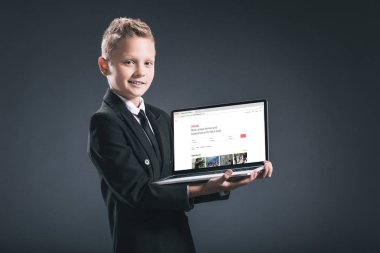 airbnb Web sitesi ile dizüstü bilgisayar ekranında gri arka plan üzerinde gösterilen işadamı takım boy gülümseyerek