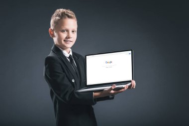 google web sitesi ile dizüstü bilgisayar ekranında gri arka plan üzerinde gösterilen işadamı takım boy gülümseyerek