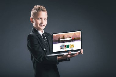 shutterstock Web sitesi ile dizüstü bilgisayar ekranında gri arka plan üzerinde gösterilen işadamı takım boy gülümseyerek