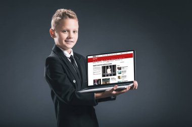 bbc Web sitesi ile dizüstü bilgisayar gri arka plan üzerinde gösterilen işadamı takım boy gülümseyerek