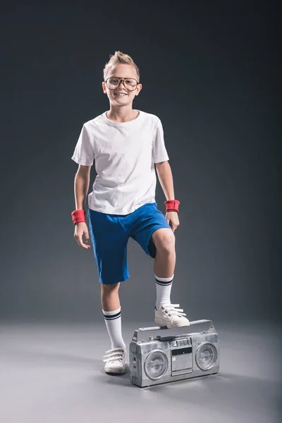 Χαμογελώντας Preteen Αγόρι Γυαλιά Boombox Θέτοντας Γκρίζο Φόντο — Φωτογραφία Αρχείου