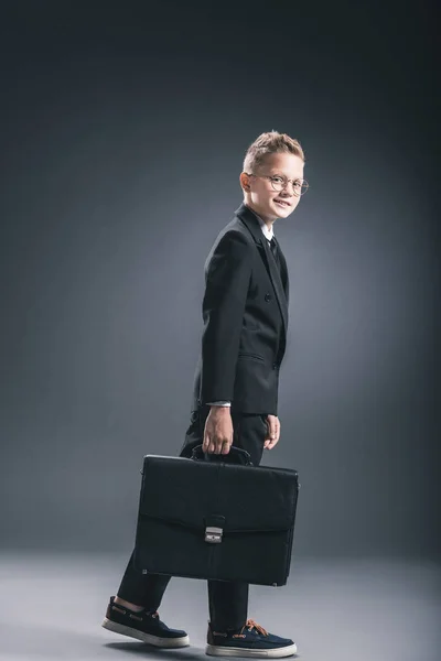 Side View Preteen Boy Businessman Suit Eyeglasses Suitcase Dark Background — Free Stock Photo
