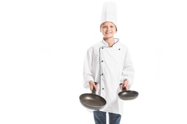 Beyaz Şef üniforma ve tavalar tutarak ve üzerinde beyaz izole kamera seyir şapka boy gülümseyerek