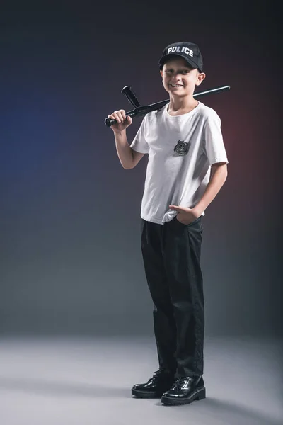 Lächelnder Junge Weißem Shirt Und Mütze Polizeiuniform Mit Knüppel Vor — kostenloses Stockfoto