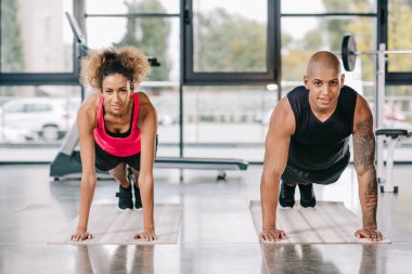 mutlu genç Afro-Amerikan çift tahta üzerinde fitness yapıyor sporcuların spor paspaslar