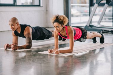 genç Afro-Amerikan çift tahta üzerinde fitness yapıyor sporcuların spor paspaslar