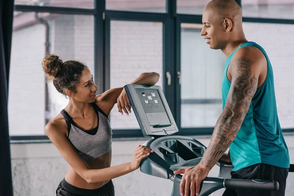 Unga Kvinnliga Tränare Ser Afroamerikanska Sportsman Kör Löpband Gym — Stockfoto