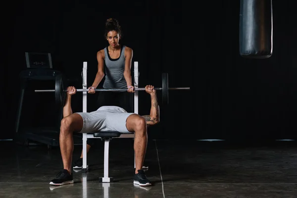 Young African American Woman Helping Boyfriend Exercising Barbell Gym — Stock Photo, Image