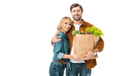 kağıt poşet ürünleri ile tutarak ve üzerinde beyaz izole kız kucaklayan delikanlı